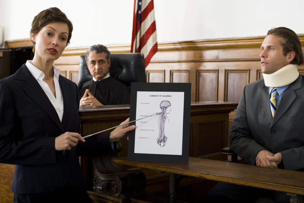 A female personal injury lawyer helps a client pursue his lawsuit in a courtroom in Chattanooga.