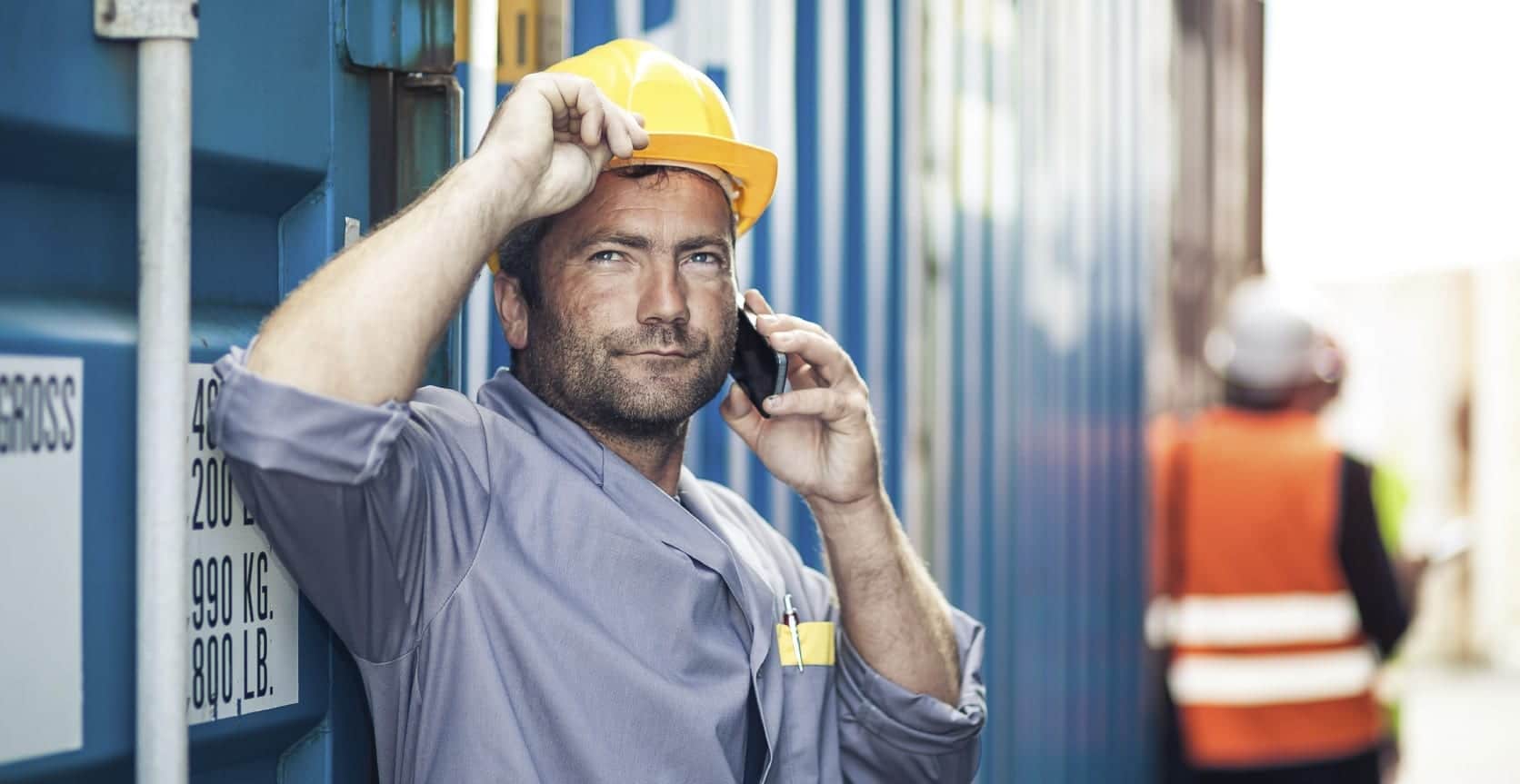 Construction Worker In Hard Hat Talking On Mobile Device Stock Photo