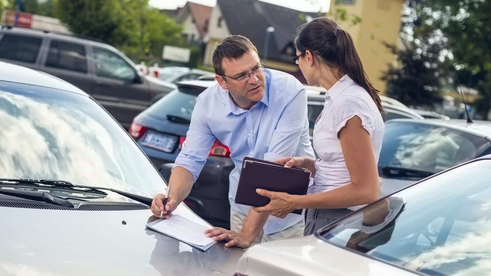 Man And Woman Exchanging Insurance Information After Car Accident Stock Photo