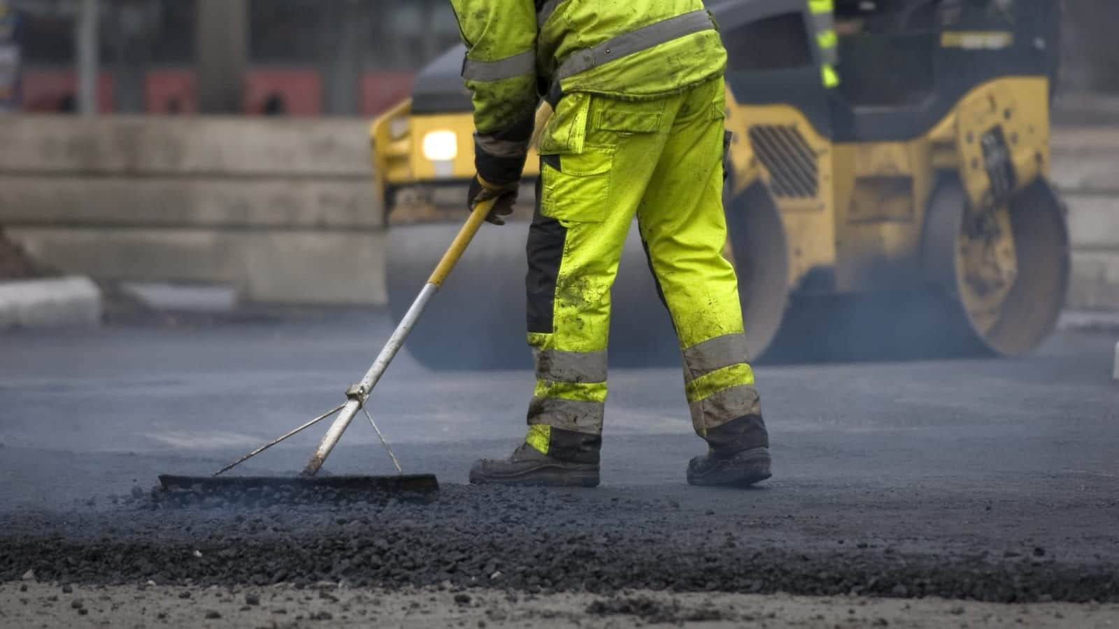 Road Construction Worker Laying Blacktop Stock Photo