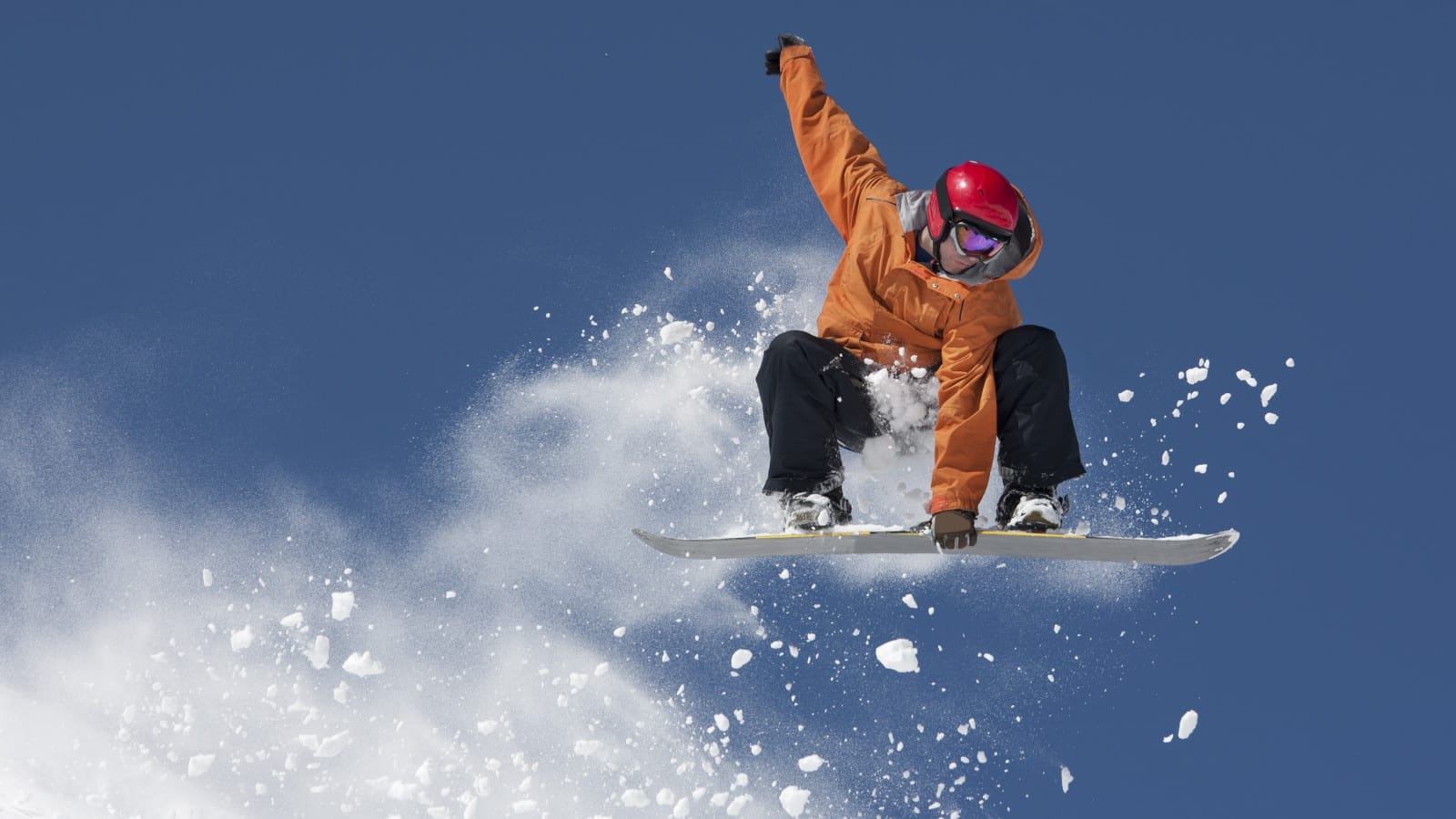 Young Man Flying Through The Air On A Snowboard Stock Photo