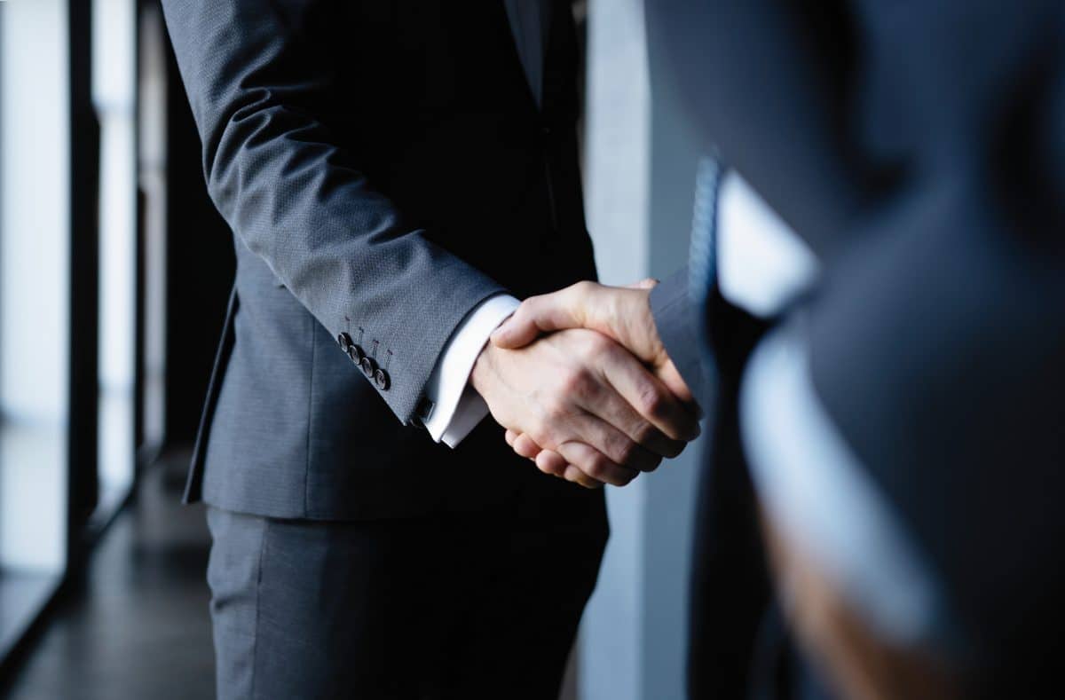 An experienced personal injury attorney in Chattanooga shakes a hands with a client after helping them win a car accident case that went to trial.